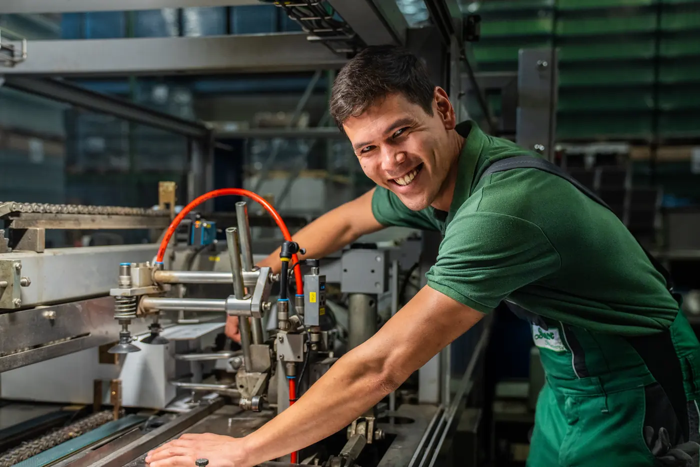 Mitarbeiter in Sartor-Arbeitskleidung stellt eine Maschine ein