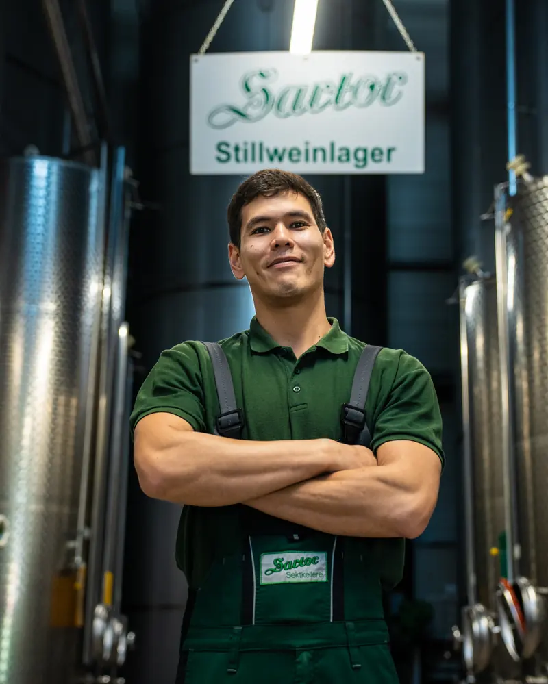 Mitarbeiter in Sartor-Arbeitskleidung unter dem Schild Stillweinlager